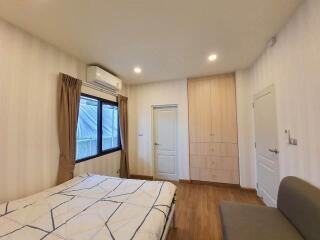 Cozy bedroom with double bed, built-in closet, and split air conditioner