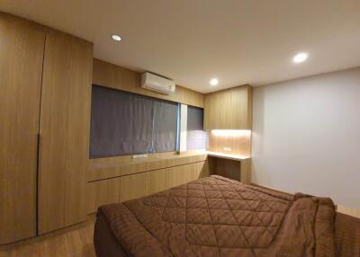 Bedroom with wooden furniture and brown bedspread