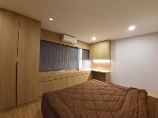 Bedroom with wooden furniture and brown bedspread