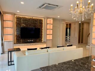 Modern living room with chandelier and built-in shelving