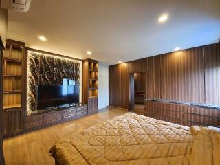 Modern bedroom with accent wall and large TV