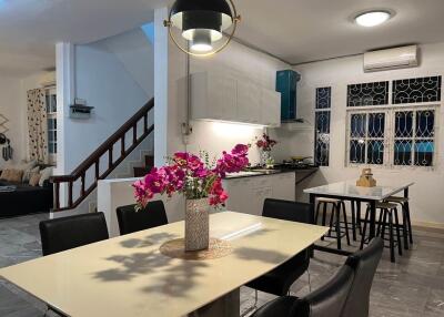 Modern kitchen and dining area with contemporary lighting and floral centerpiece