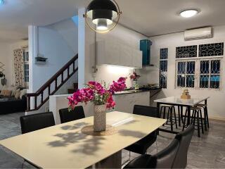 Modern kitchen and dining area with contemporary lighting and floral centerpiece