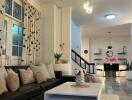 Modern living room with black leather couch, coffee table, and contemporary lighting.