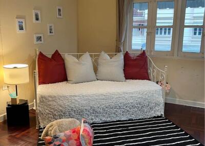 Cozy living room with daybed, striped rug, and a pendant light