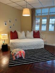 Cozy living room with daybed, striped rug, and a pendant light