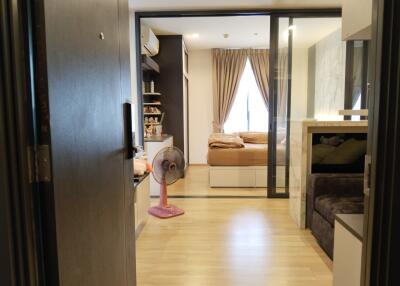 Bedroom with sliding glass door, wooden floor, and neutral decor