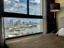 Bedroom with a large window and city view