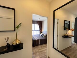 View into a stylish bedroom with modern decor reflected in a hallway mirror