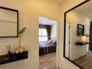 View into a stylish bedroom with modern decor reflected in a hallway mirror