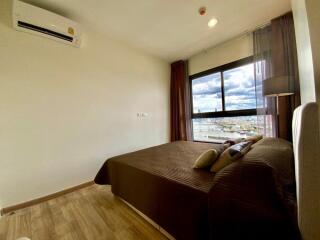 Bedroom with large window and city view