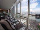 Lounge area with massage chairs and cityscape view through large windows