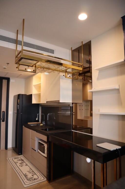 Modern kitchen with black granite countertops and gold shelving