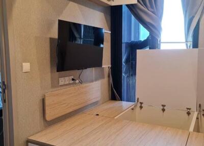 Modern bedroom with built-in storage and wall-mounted TV