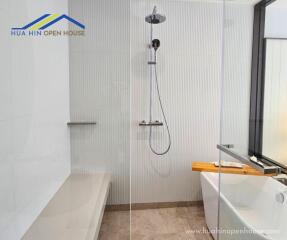 Modern bathroom with walk-in shower, bathtub, and bench