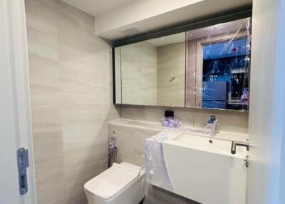 Modern bathroom with large mirror and white fixtures