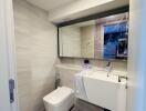 Modern bathroom with large mirror and white fixtures