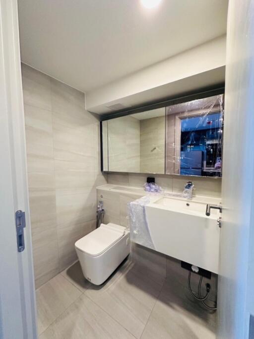 Modern bathroom with large mirror and white fixtures