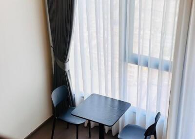 Small dining area with table and chairs near large windows