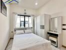 Modern bedroom with a large bed, wardrobe, and a vanity desk