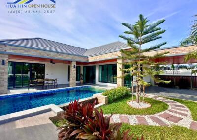 Exterior view of a modern house with a pool and garden