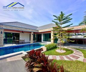 Exterior view of a modern house with a pool and garden