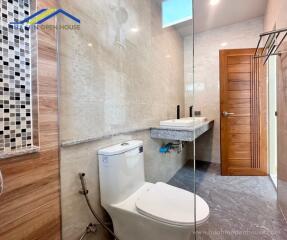 Modern bathroom with toilet, sink, and glass shower enclosure