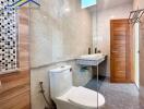 Modern bathroom with toilet, sink, and glass shower enclosure