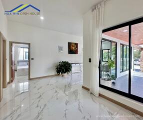 Modern living space with glossy marble flooring, large windows, and indoor-outdoor space connection