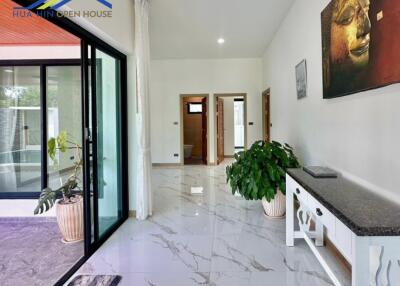 Spacious and bright hallway with marble flooring and potted plants