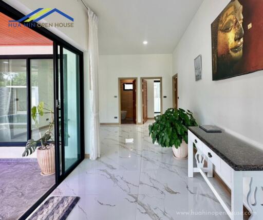 Spacious and bright hallway with marble flooring and potted plants