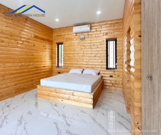 Bedroom with wooden walls and tiled floor