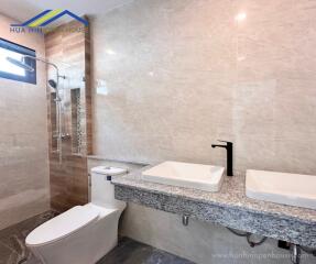 Modern bathroom with two sinks and a shower area