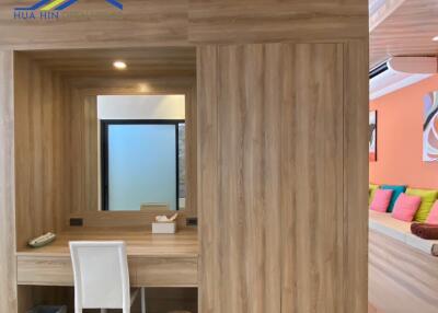 Well-lit bedroom with wooden decor and a built-in vanity area