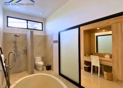 Modern bathroom with a freestanding bathtub, shower, and vanity area