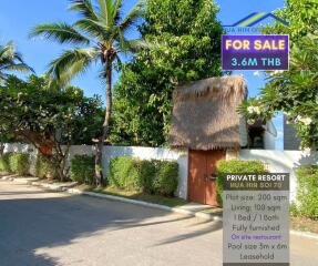 Private resort exterior with tropical trees, a thatched entrance gate, and a 