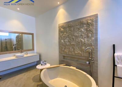 Modern bathroom with oval freestanding bathtub and decorative wall art