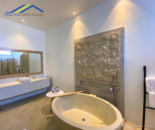 Modern bathroom with oval freestanding bathtub and decorative wall art