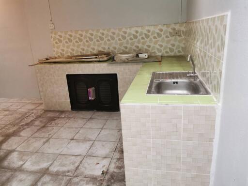 Basic kitchen with a sink and tiled countertops