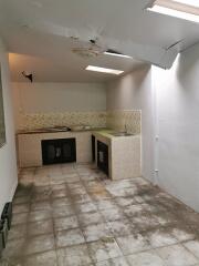 Small unfinished kitchen with tiled floor and countertop