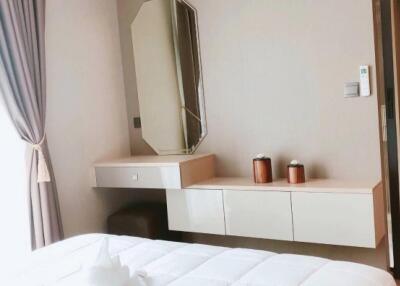 Bedroom with air conditioner, mirror, side table, and neatly made bed