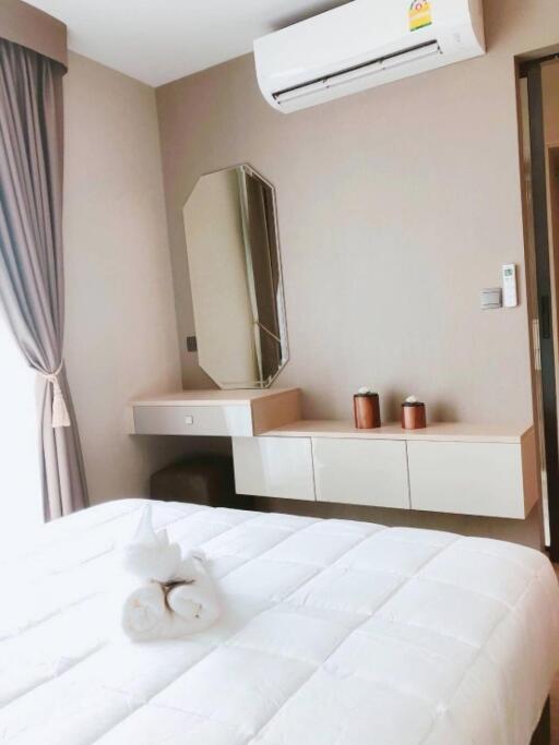 Bedroom with air conditioner, mirror, side table, and neatly made bed