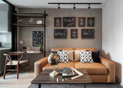 A modern living room with a brown sofa, wall decorations, a coffee table and a desk area.