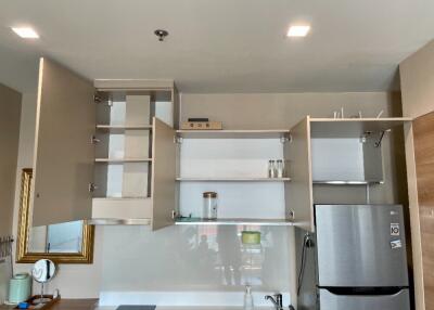 Modern kitchen with open cabinets and stainless steel fridge