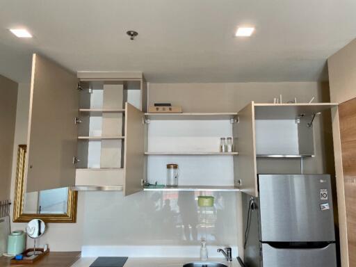 Modern kitchen with open cabinets and stainless steel fridge