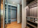 Spacious walk-in closet with wooden flooring and open shelves