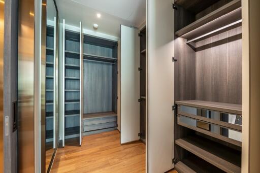 Spacious walk-in closet with wooden flooring and open shelves