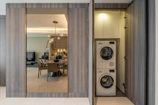 A modern living space with dining area, kitchen, and laundry nook.