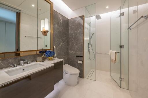 Modern bathroom with glass shower and marble walls