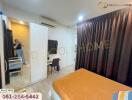 Well-lit bedroom with study area and mirrored wardrobe